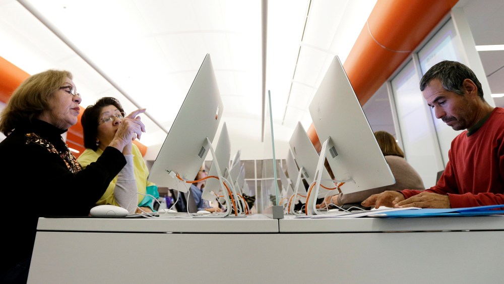 Caroline Ramirez and Sam Martinez use computers at a public library to access the Affordable Health Care Act website, in San Antonio, Texas, Dec. 23, 2013.