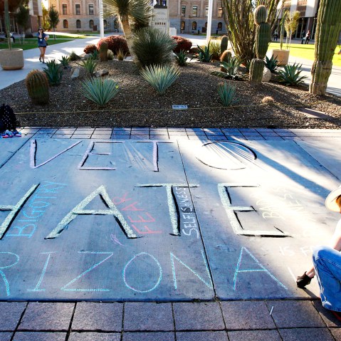 Margaret Jean Plews works on a chalk drawing as she joined nearly 250 gay rights supporters protesting SB1062 at the Arizona Capitol, Feb. 21, 2014.