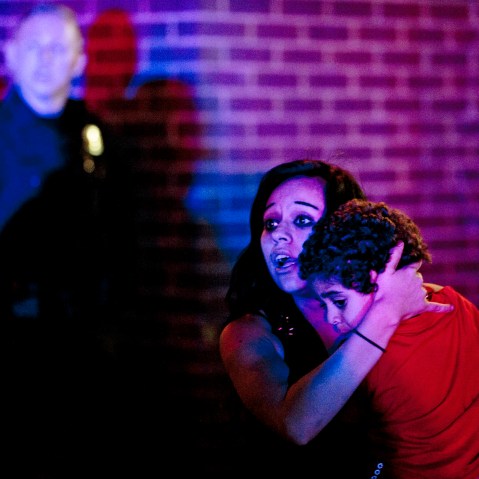 A woman holds a young boy as a crowd of people clash with police following an officer-involved shooting at 200 South Rio Grande Street in Salt Lake City, Feb. 27, 2016. (Photo by Lennie Mahler/The Salt Lake Tribune/AP)