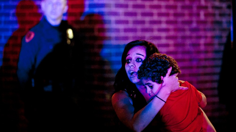 A woman holds a young boy as a crowd of people clash with police following an officer-involved shooting at 200 South Rio Grande Street in Salt Lake City, Feb. 27, 2016. (Photo by Lennie Mahler/The Salt Lake Tribune/AP)