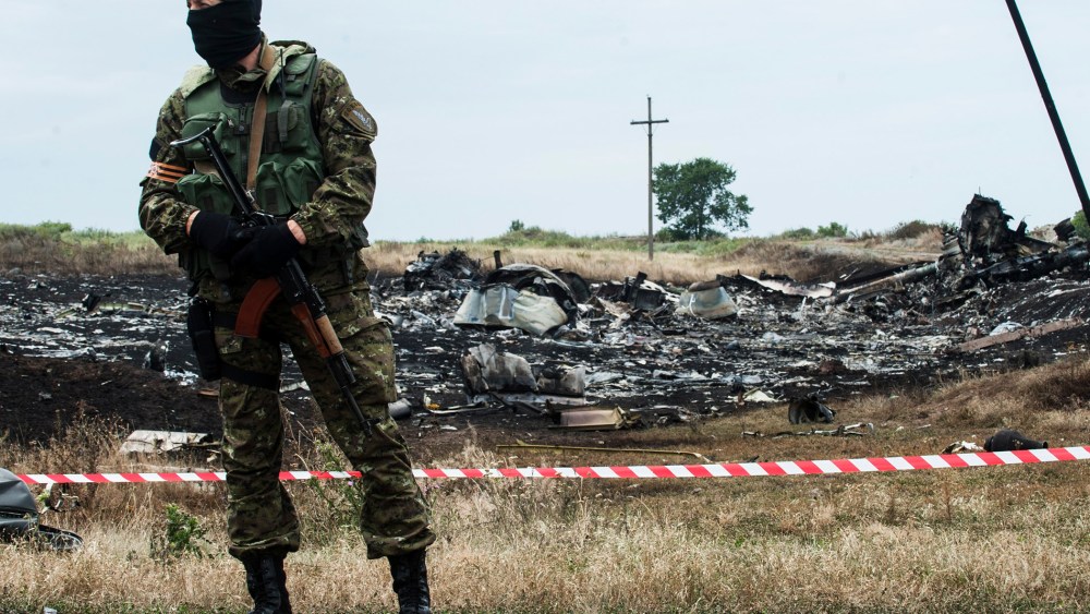 A pro-Russian fighter guards the crash site of a Malaysia Airlines jet near the village of Hrabove, eastern Ukraine, July 19, 2014.