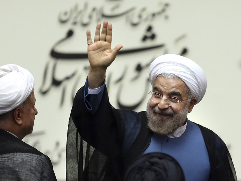 Iran's new President Hasan Rouhani, waves after swearing in at the parliament, in Tehran, Iran, Sunday, Aug. 4, 2013. (Photo by Ebrahim Noroozi/AP)