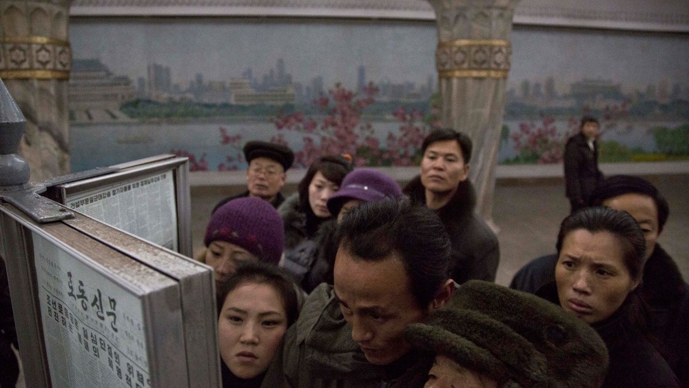 North Korean subway commuters gather around a public newspaper stand on the train platform in Pyongyang, North Korea on Dec. 13, 2013 to read the headlines about Jang Song Thaek, North Korean leader Kim Jong Un's uncle who was executed as a traitor.