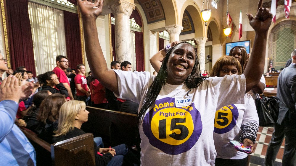 Workers react as the Los Angeles City Council votes 13-1 to raise the minimum wage to $15 an hour by 2020, but a second vote is required for final approval because the tally was not unanimous, in Los Angeles, June 3, 2015. (Photo by Damian Dovarganes/AP)