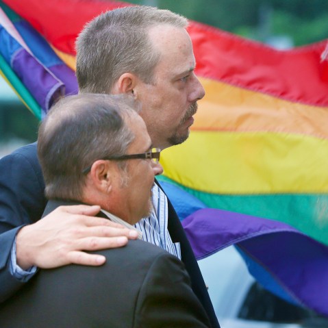 In this photo taken May 12, 2014, Shon DeArmon, top, and his partner James Porter carry a flag in support of the county issuing marriage licenses for same-sex couples at the Pulaski County Courthouse in Little Rock, Ark. (Photo by Danny Johnston/AP)