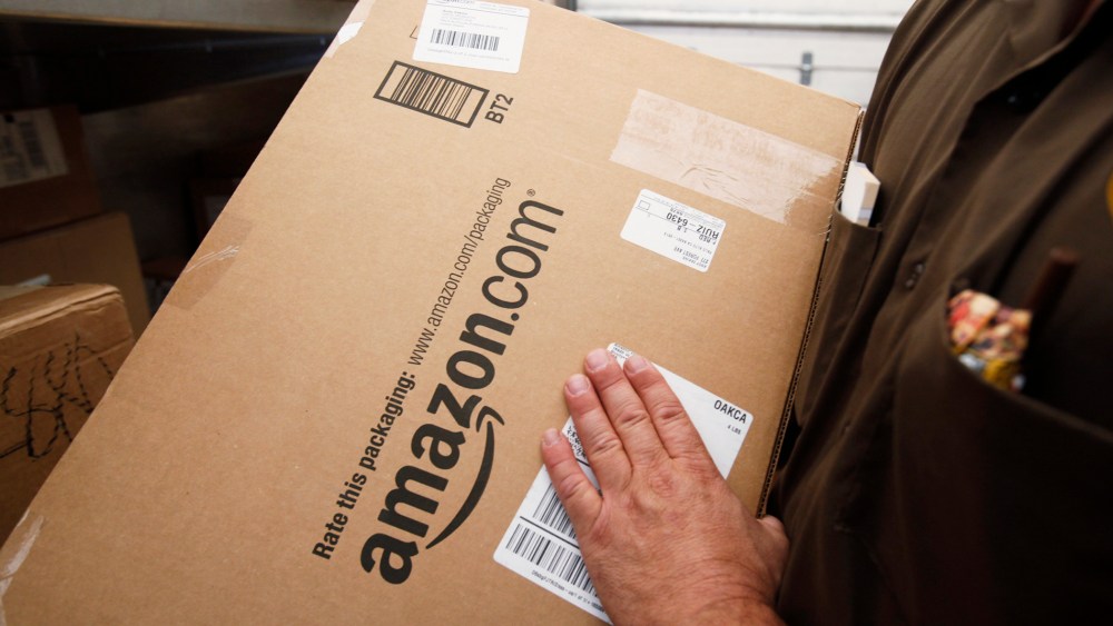 In this Oct. 18, 2010 file photo, a United Parcel Service (UPS) driver lifts an Amazon.com box in Palo Alto, Calif.