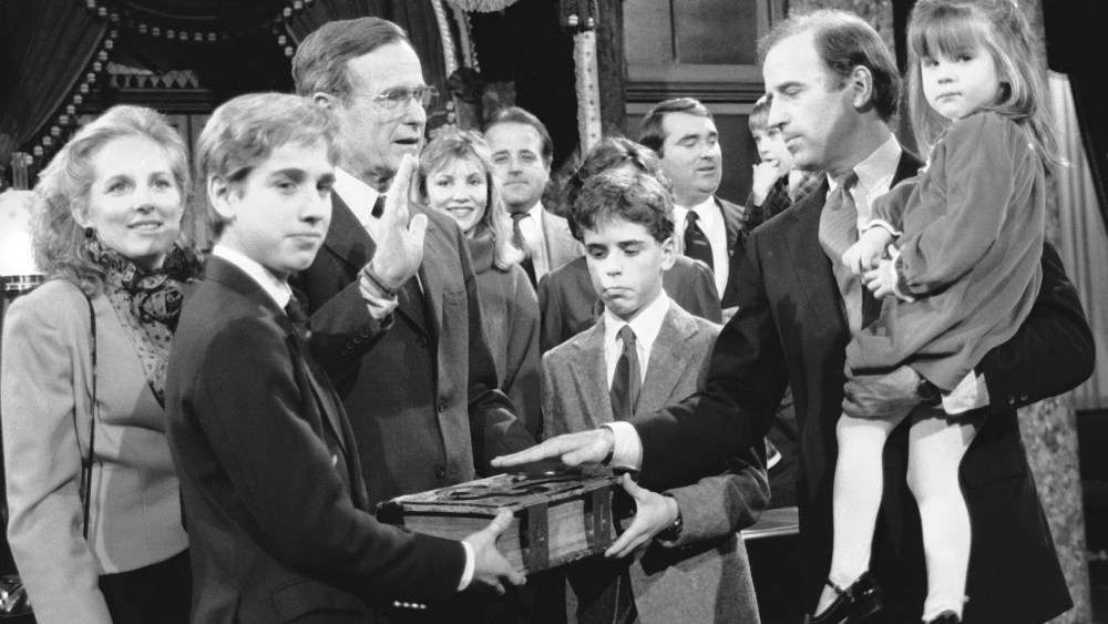 Sen. Joe Biden holds his daughter Ashley while taking a mock oath of office from Vice President George Bush during a ceremony on Capitol Hill, Jan. 3, 1985. Biden's sons Beau and Hunter hold the bible during the ceremony. (Photo by Lana Harris/AP)