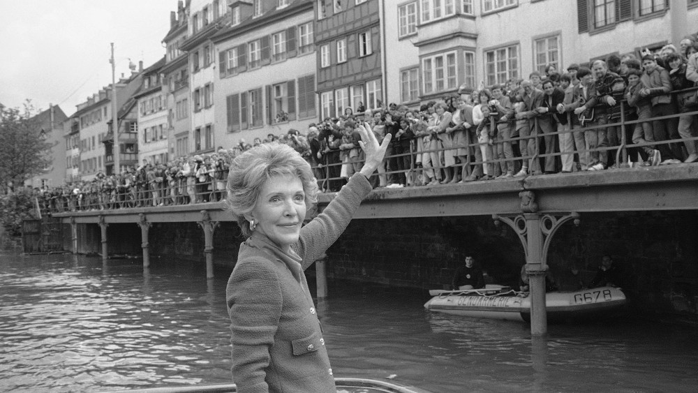 First Lady Nancy Reagan turns around and waves to a crowd alongside the river Ill where she was invited for a boat ride in this picturesque quarter, May 8, 1985, Strasbourg, France. (Anonymous/AP)