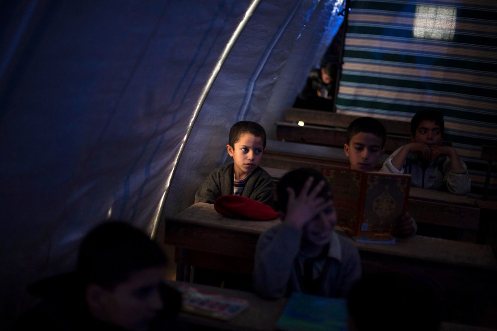 Displaced Syrian children attend school in a makeshift classroom in the Azaz camp for displaced people, north of Aleppo province, Syria, on Feb. 20, 2013.