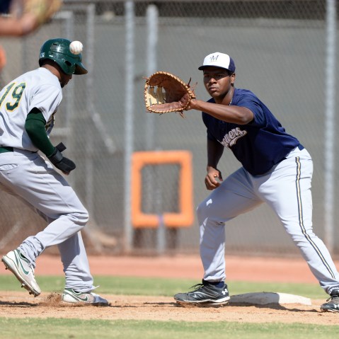 Milwaukee Brewers first baseman David Denson (8) takes a throw as D'Arby Myers (19) gets back to the bag during an Instructional League game against the Oakland Athletics, Oct. 10, 2013, Phoenix, Ariz. (Photo by Mike Janes/Four Seam Images/AP)