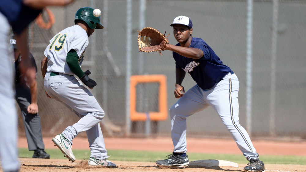 Milwaukee Brewers first baseman David Denson (8) takes a throw as D'Arby Myers (19) gets back to the bag during an Instructional League game against the Oakland Athletics, Oct. 10, 2013, Phoenix, Ariz. (Photo by Mike Janes/Four Seam Images/AP)