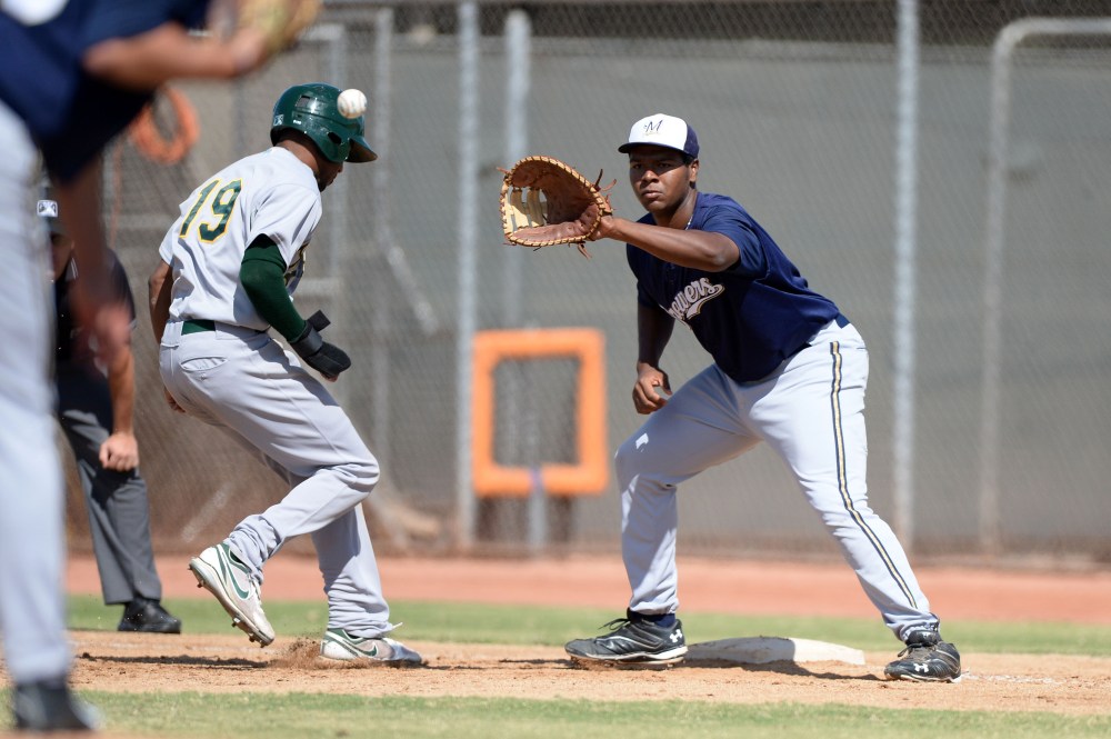 Milwaukee Brewers first baseman David Denson (8) takes a throw as D'Arby Myers (19) gets back to the bag during an Instructional League game against the Oakland Athletics, Oct. 10, 2013, Phoenix, Ariz. (Photo by Mike Janes/Four Seam Images/AP)