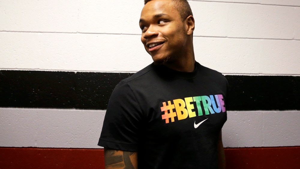 University of Massachusetts basketball guard Derrick Gordon, 22, enters a hallway before facing reporters on the school's campus, April 9, 2014.