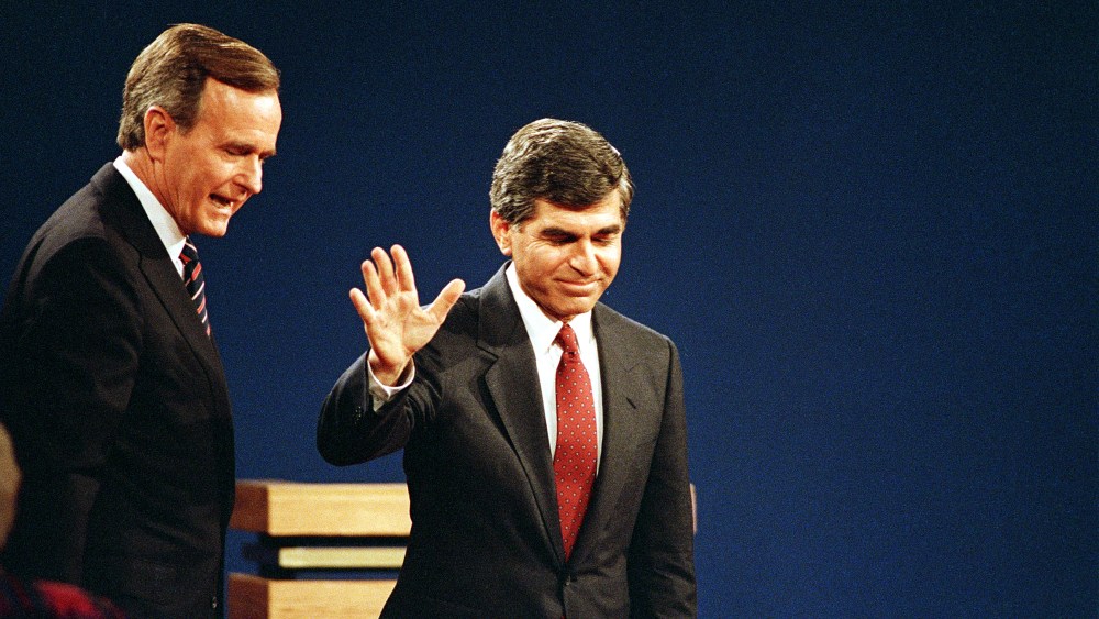 Democratic presidential candidate Michael Dukakis acknowledges the auditorium as Republican presidential candidate,Vice President George Bush, looks on after their final debate in Los Angeles, California, Oct, 13, 1988.