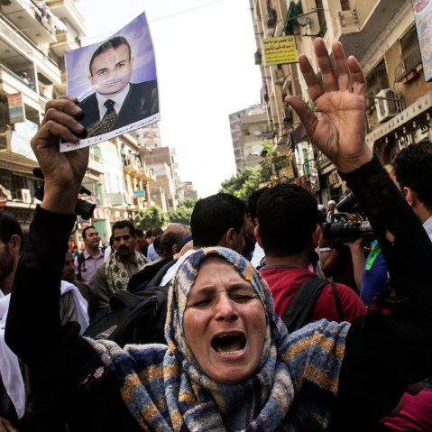 An Egyptian woman holds a photo of her son after a judge sentenced to death 683 alleged supporters of the country's ousted Islamist president in the latest mass trial in the southern city of Minya, Egypt, April 28, 2014.
