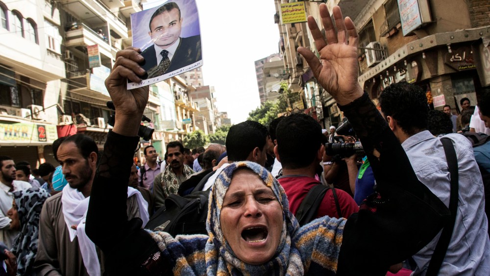 An Egyptian woman holds a photo of her son after a judge sentenced to death 683 alleged supporters of the country's ousted Islamist president in the latest mass trial in the southern city of Minya, Egypt, April 28, 2014.