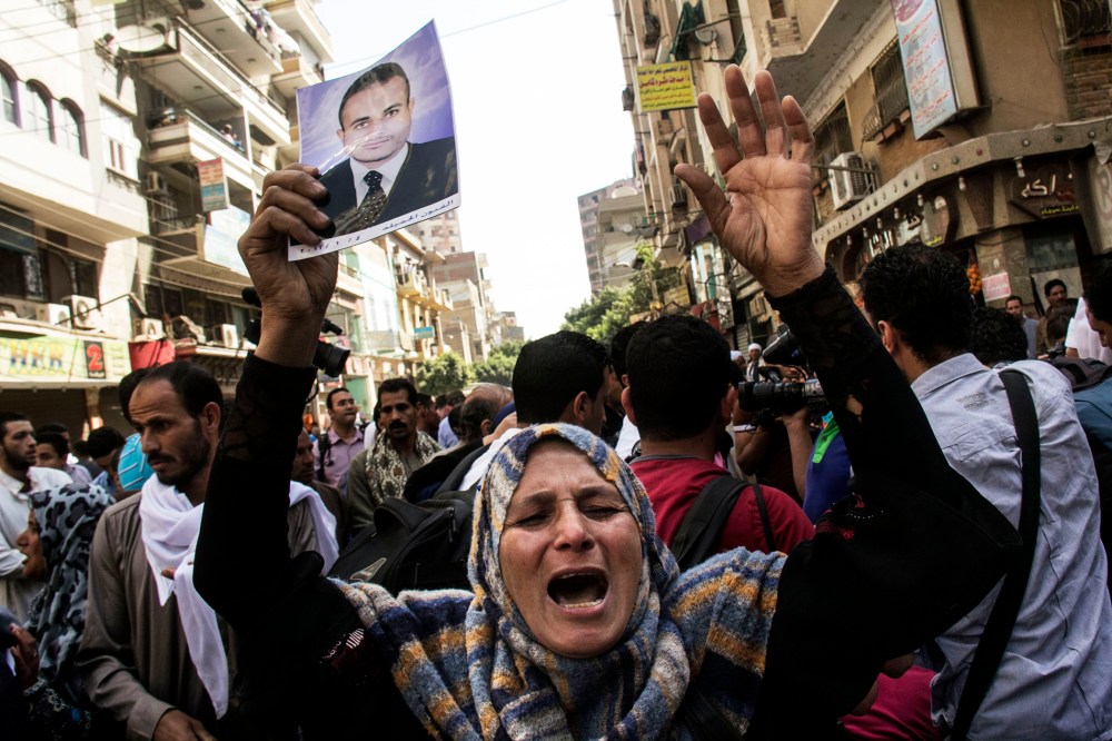 An Egyptian woman holds a photo of her son after a judge sentenced to death 683 alleged supporters of the country's ousted Islamist president in the latest mass trial in the southern city of Minya, Egypt, April 28, 2014.