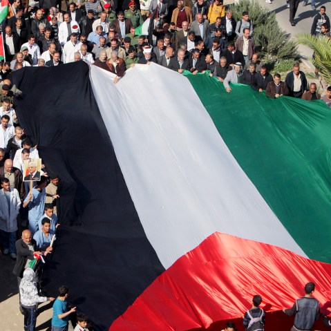 People hold a giant Palestinian flag during a rally in support of the Palestinian UN bid for observer state status, in the West Bank town of Jenin, Thursday, Nov. 29, 2012. The Palestinians are certain to win U.N. recognition as a state on Thursday but...