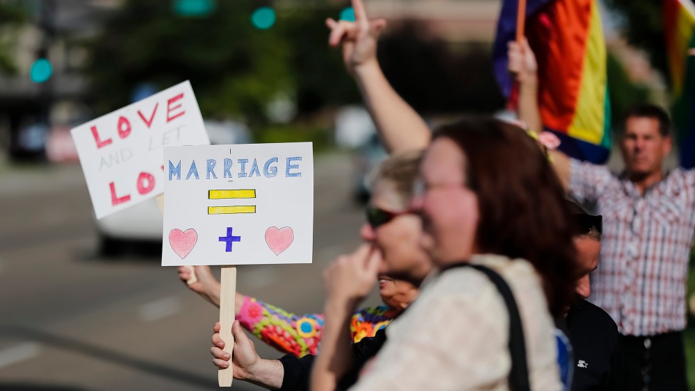 Gay marriage supporters hold up signs and rainbow flags for passing traffic at the Ada County Courthouse in Boise, Idaho, May 16, 2014.