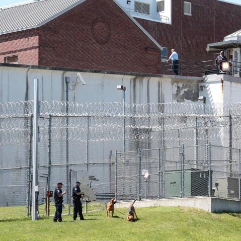 Law enforcement officers with bloodhounds stand guard at one of the entrances to the Clinton Correctional Facility in Dannemora, N.Y. on Saturday, June 6, 2015. (Photo by Gabe Dickens/Press-Republican/AP)
