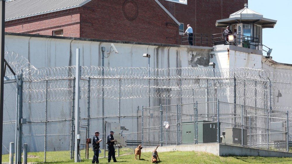 Law enforcement officers with bloodhounds stand guard at one of the entrances to the Clinton Correctional Facility in Dannemora, N.Y. on Saturday, June 6, 2015. (Photo by Gabe Dickens/Press-Republican/AP)