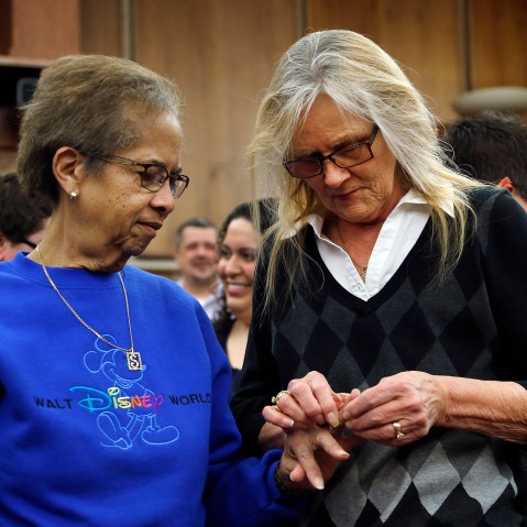 Pennye Mattson, right, places a wedding ring on Sherrie Tyler, left, while being married by the Oakland County Clerk in Pontiac, Mich., March 22, 2014.