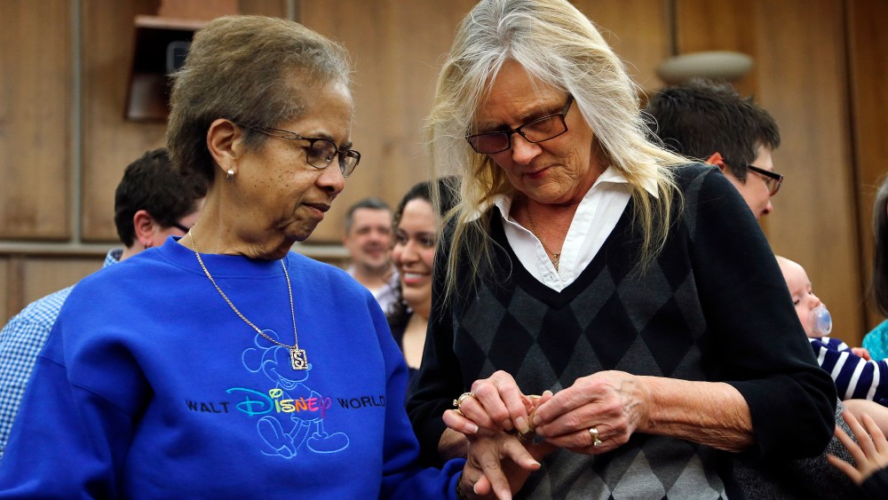 Pennye Mattson, right, places a wedding ring on Sherrie Tyler, left, while being married by the Oakland County Clerk in Pontiac, Mich., March 22, 2014.