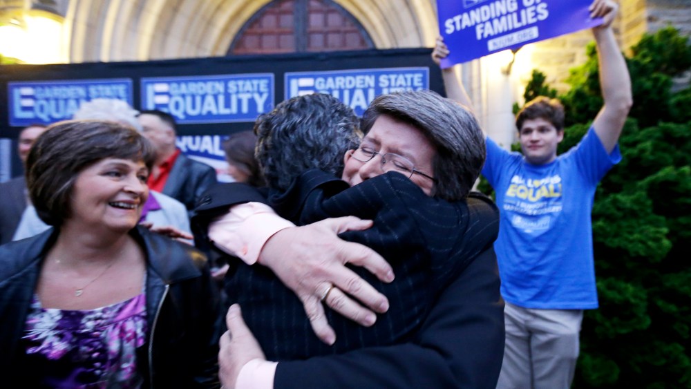 Cindy Meneghin hugs her attorney during a rally at Garden State Equality in Montclair, N.J., hours after same-sex marriages were made legal by a state judge, Friday, Sept. 27, 2013.