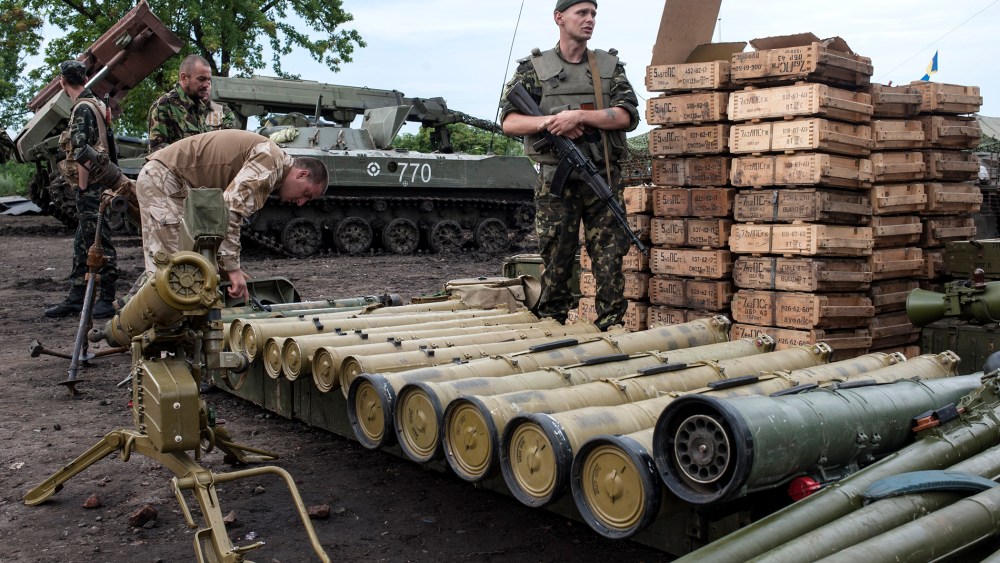 Ukrainian government soldiers guard weapons captured from rebels in Devhenke village, eastern Ukraine, July 8, 2014.