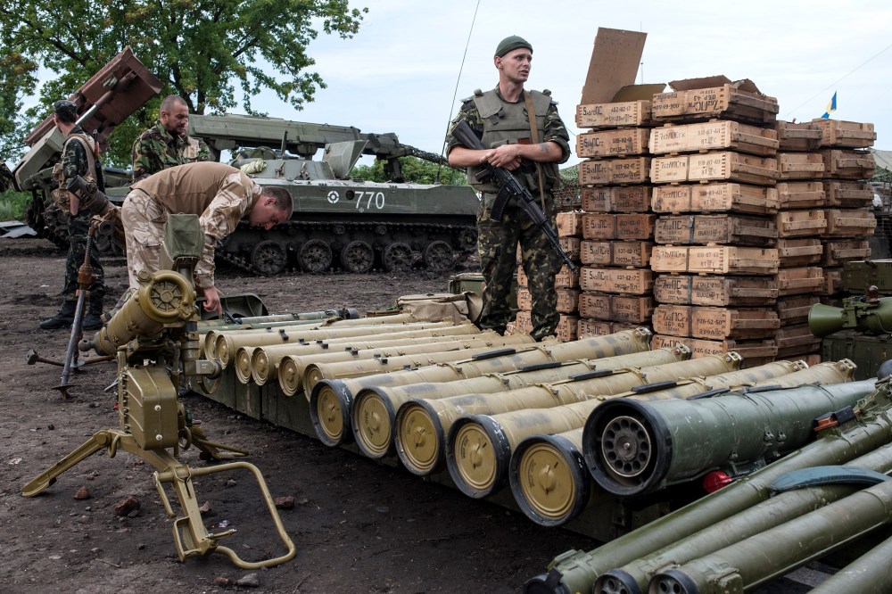Ukrainian government soldiers guard weapons captured from rebels in Devhenke village, eastern Ukraine, July 8, 2014.