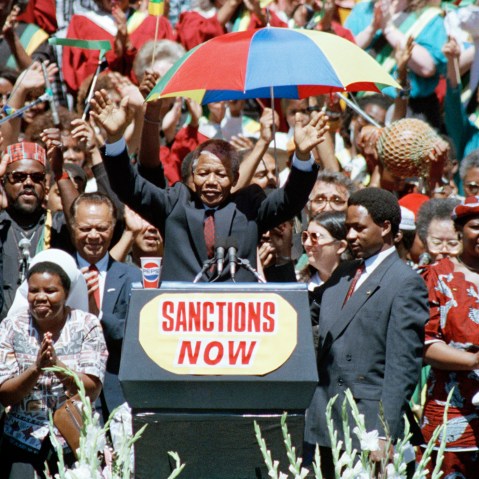 Nelson Mandela, deputy president of the African National Congress, gestures to a capacity crowd at the Oakland Coliseum on June 30, 1990, during the last stop of his eight city U.S. tour.