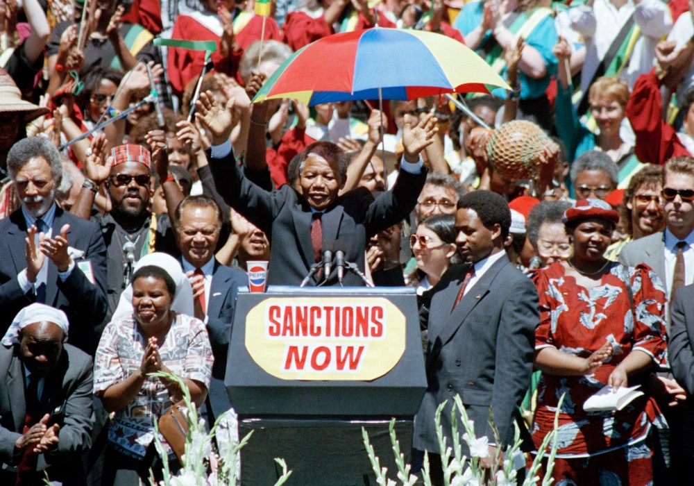 Nelson Mandela, deputy president of the African National Congress, gestures to a capacity crowd at the Oakland Coliseum on June 30, 1990, during the last stop of his eight city U.S. tour.