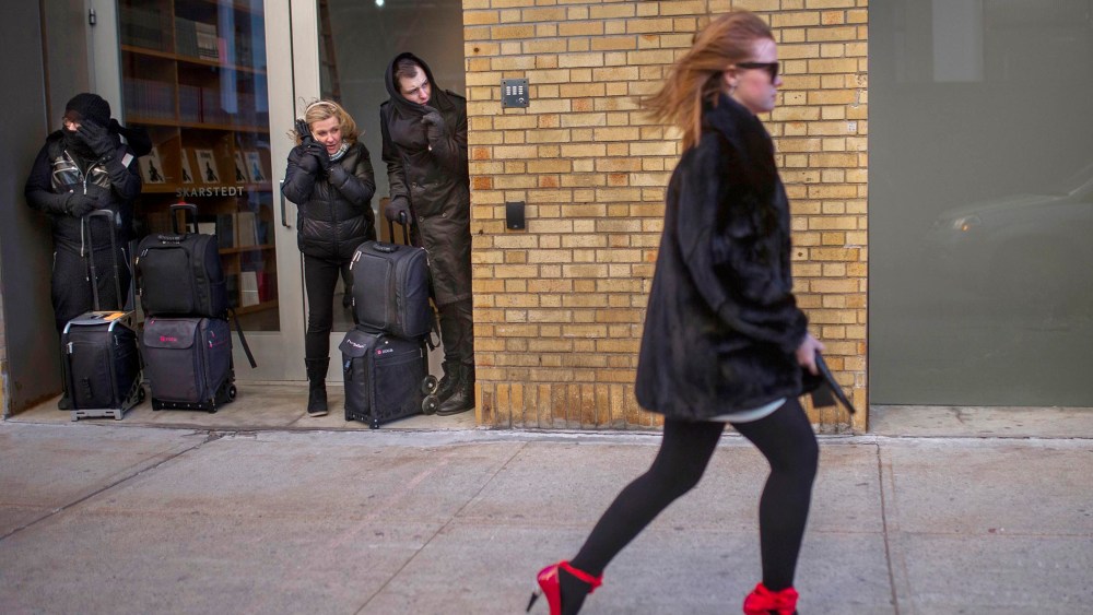 People shield themselve from the wind as a woman leaves after the Christian Siriano Fall 2016 show during Fashion Week, Feb. 13, 2016, in New York. (Photo by Andres Kudacki/AP)