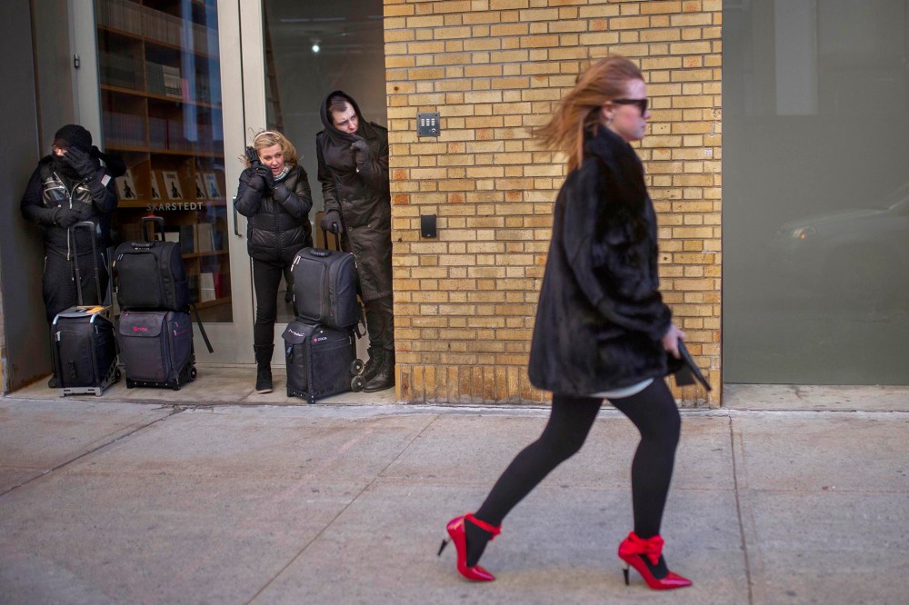 People shield themselve from the wind as a woman leaves after the Christian Siriano Fall 2016 show during Fashion Week, Feb. 13, 2016, in New York. (Photo by Andres Kudacki/AP)