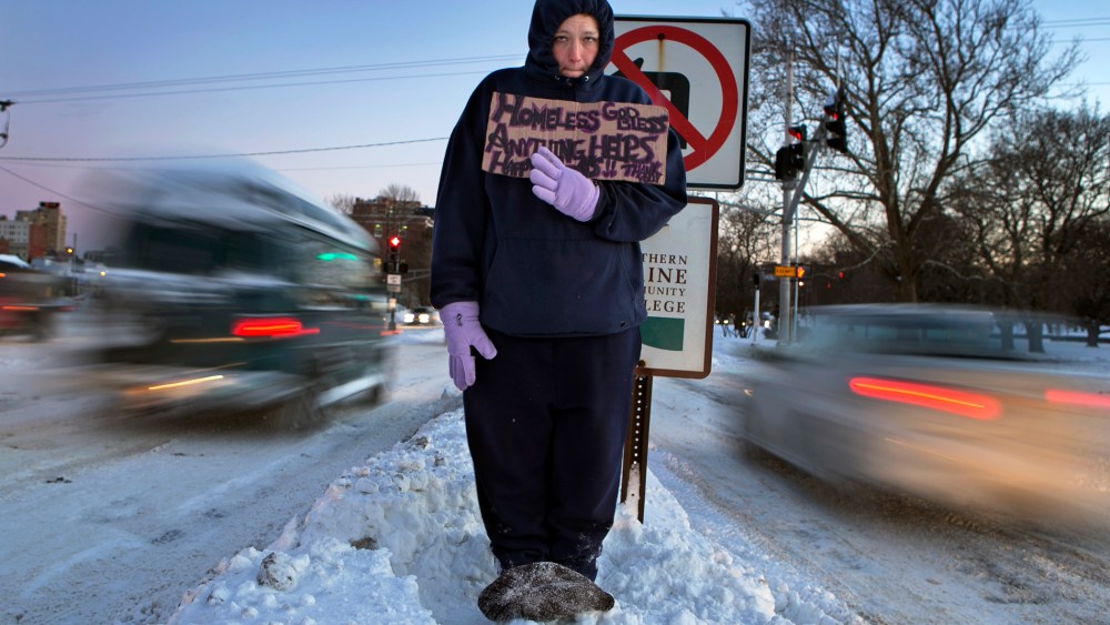 Victoria Morris, 28, panhandles in Portland, Maine, where the temperature at dusk was 7 degrees Fahrenheit, Jan. 3, 2014.