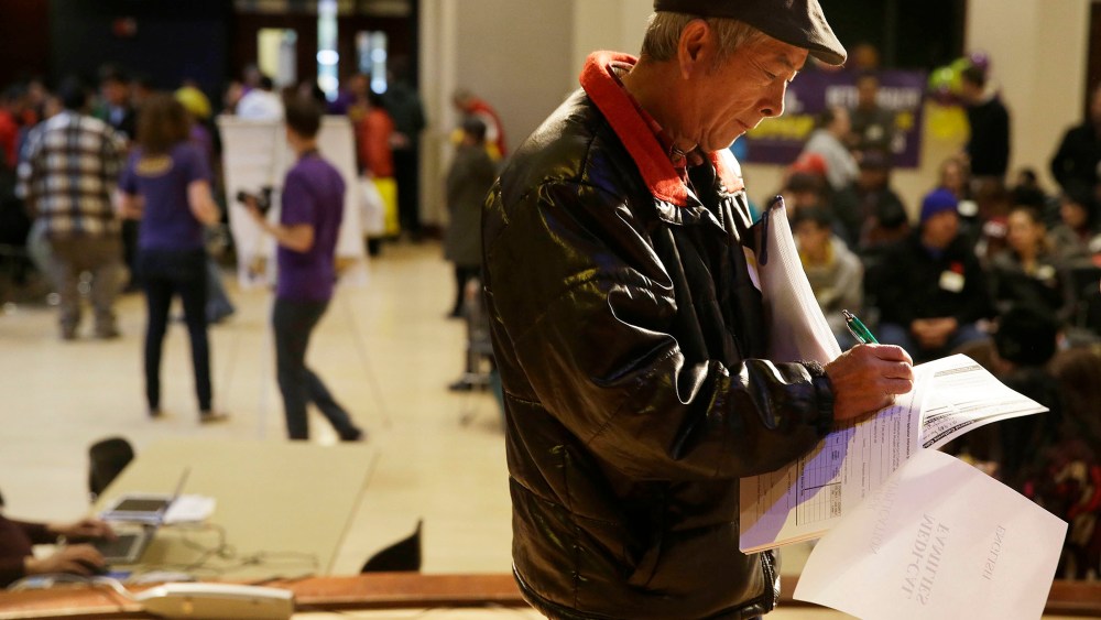 Jian Feng Liu, 57, of Fremont, Calif., finishes filling out his application form during a health care enrollment event at the Oakland Asian Cultural Center on March 31, 2014, in Oakland, Calif.