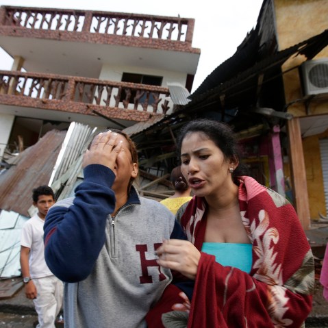 A woman cries as she stands next to house destroyed by the earthquake in the Pacific coastal town of Pedernales, Ecuador, April 17, 2016. (Photo by Dolores Ochoa/AP)