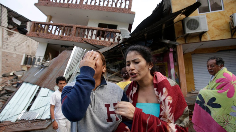 A woman cries as she stands next to house destroyed by the earthquake in the Pacific coastal town of Pedernales, Ecuador, April 17, 2016. (Photo by Dolores Ochoa/AP)