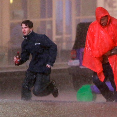 People run as weather sirens sound as a severe storm passes over downtown Dallas, Dec. 26, 2015. The National Weather Service said the Dallas area was under a tornado warning Saturday. (Photo by LM Otero/AP)