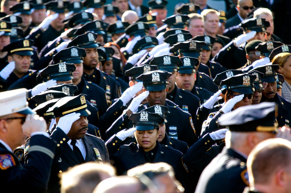 Thousands of police officers and others salute during the National Anthem as the funeral of New York City police officer Rafael Ramos begins at Christ Tabernacle Church in the Glendale section of Queens, where he was a member, Dec. 27, 2014, in New York.