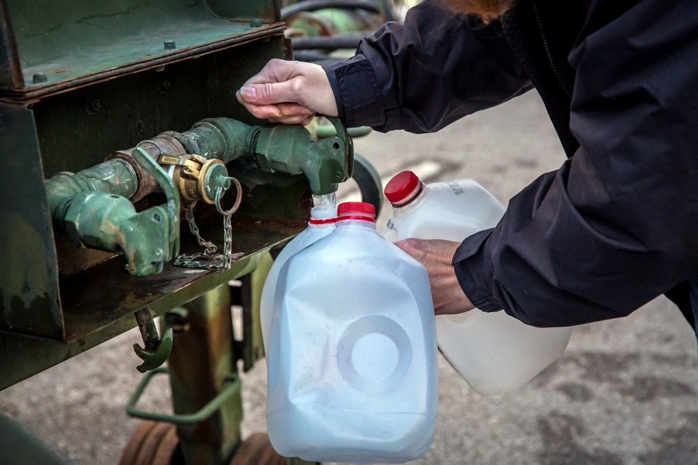 A local resident fills jugs with water at a distribution center in Charleston, W.Va., on Jan. 12, 2014.