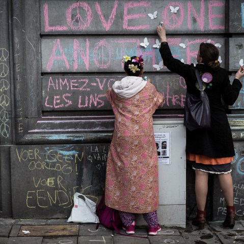 Two children write on a wall at a memorial for victims of attacks in Brussels on March 23, 2016. (Photo by Valentin Bianchi/AP)