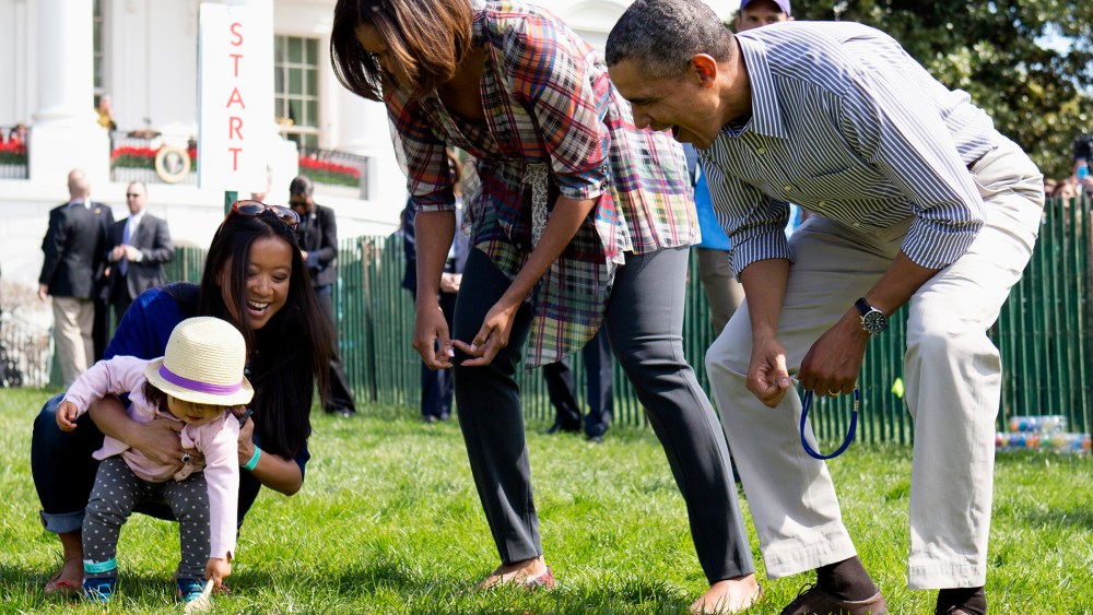 President Barack Obama and first lady Michelle Obama cheer a little egg roller as they host the White House Easter Egg Roll on the South Lawn of the White House is Washington, April 21, 2014.