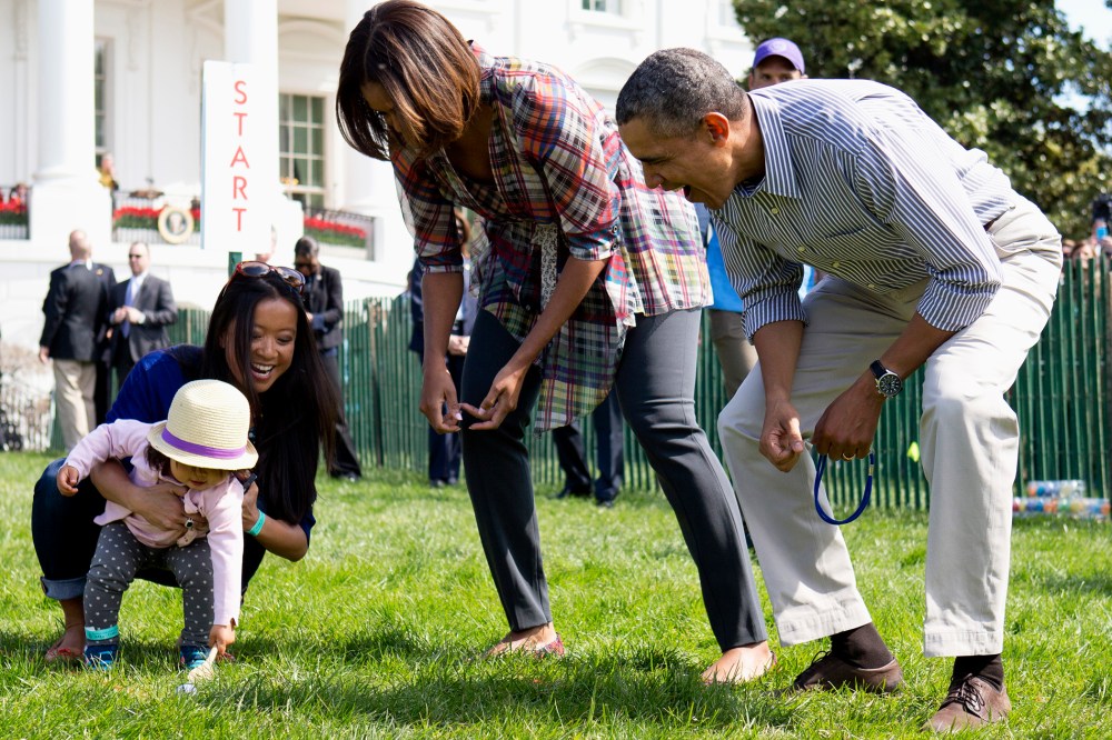 President Barack Obama and first lady Michelle Obama cheer a little egg roller as they host the White House Easter Egg Roll on the South Lawn of the White House is Washington, April 21, 2014.