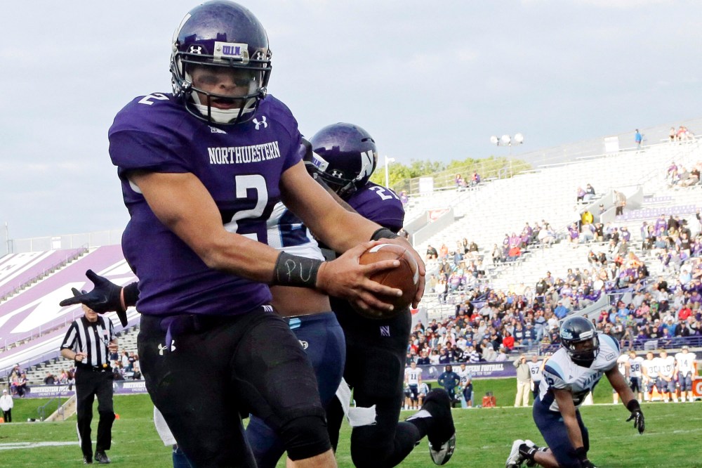 Northwestern quarterback Kain Colter (2), wears APU for "All Players United" on wrist tape as he scores a touchdown, Sept. 21, 2013.