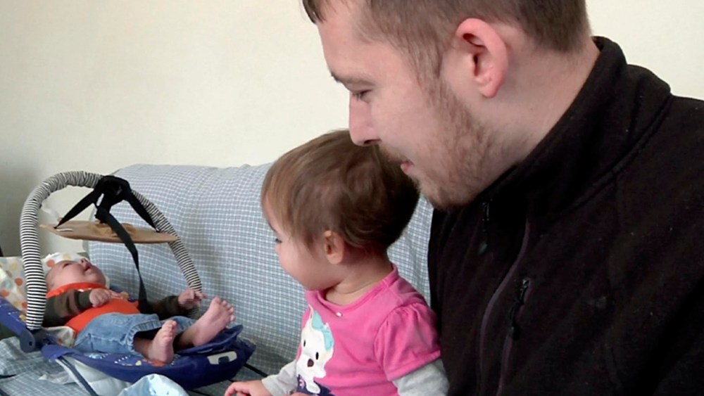 Luke Waid discusses the lead-contamination in Flint's water as he watches his 2-year-old daughter, Sophia, and infant son, Luke Jr, in their Flint, Mich., home. (Photo by Mike Householder/AP)