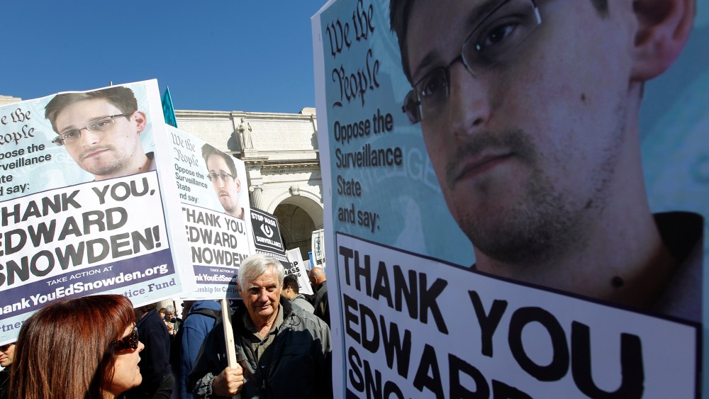 Demonstrators holds up banners with the photo of Edward Snowden during a protest outside of the U.S. Capitol in Washington, on Saturday, Oct. 26, 2013.