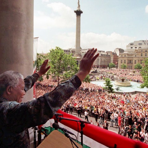 South African President Nelson Mandela acknowledges the cheers of the vast Trafalgar Square crowd from the balcony of South Africa House in London, July 12 1996.