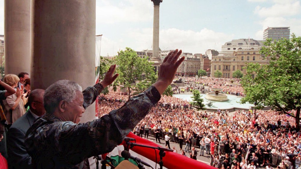 South African President Nelson Mandela acknowledges the cheers of the vast Trafalgar Square crowd from the balcony of South Africa House in London, July 12 1996.