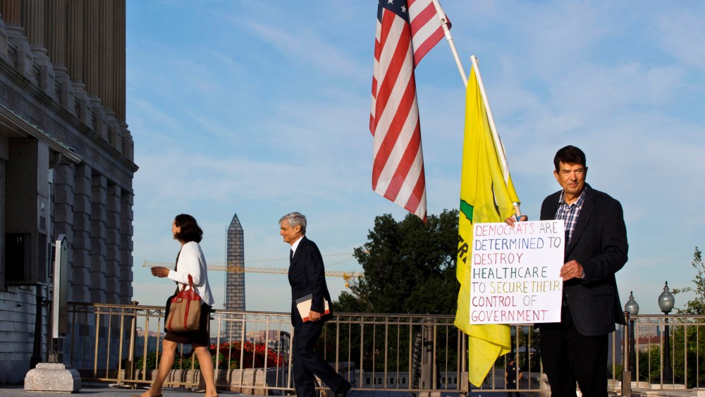 A member of the Tea Party holds a sign against Obamacare outside the Senate side of the Capitol in Washington, Wednesday, Sept. 25, 2013.